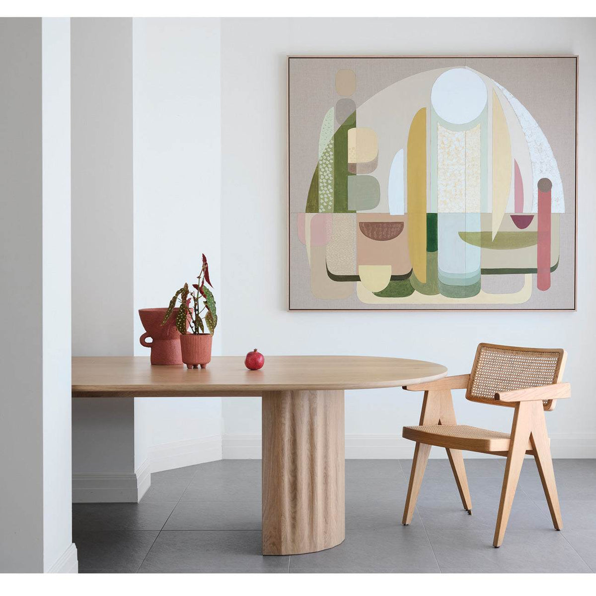 A framed Giclee print displayed on a wall above a dining table and chairs, featuring an abstract design with a warm color palette.
