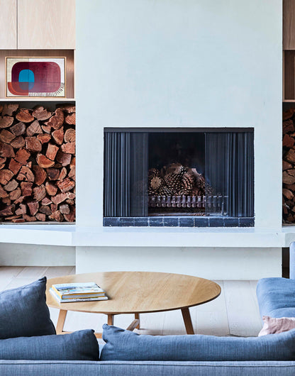 Modern living room with a fireplace, blue sofa, and wooden coffee table.