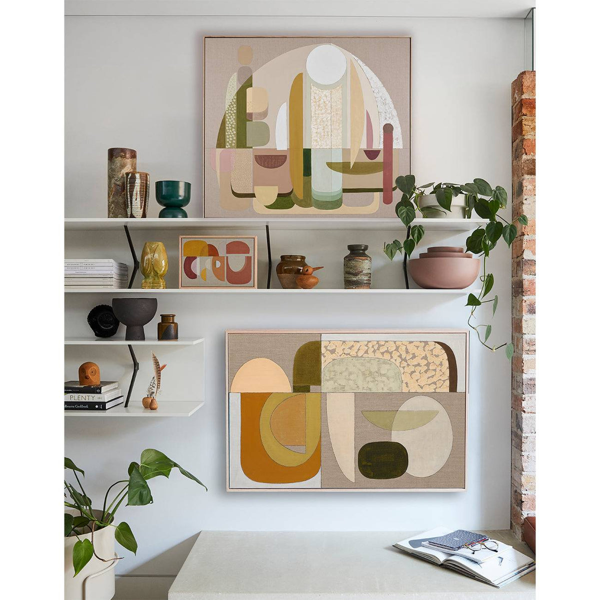 A framed Giclee print displayed on a wall above a dining table and chairs, featuring an abstract design with a warm color palette.