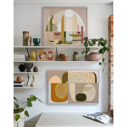 A framed Giclee print displayed on a wall above a dining table and chairs, featuring an abstract design with a warm color palette.