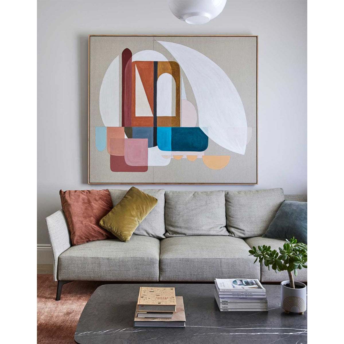 A framed Giclee print featuring a stylized, abstract representation of 'The Arch' hanging above a sofa in a living room setting.