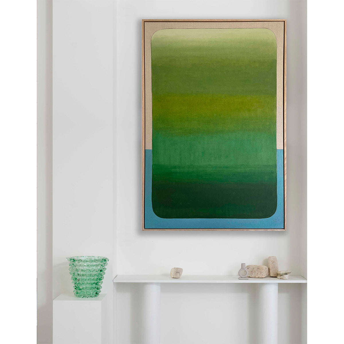 Framed abstract art with green and blue gradient on a white wall