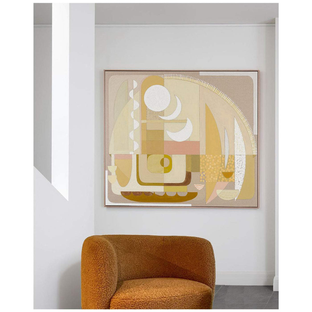 A framed Giclee print hanging on a wall above an orange armchair, featuring abstract geometric shapes in yellow, brown, and pink tones.