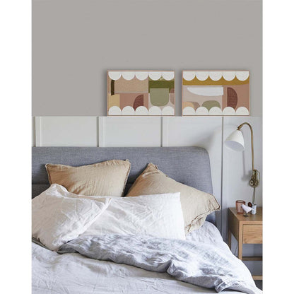 Framed Giclee print featuring geometric shapes in khaki and beige tones with white scalloped bands, displayed above a bed with pillows.