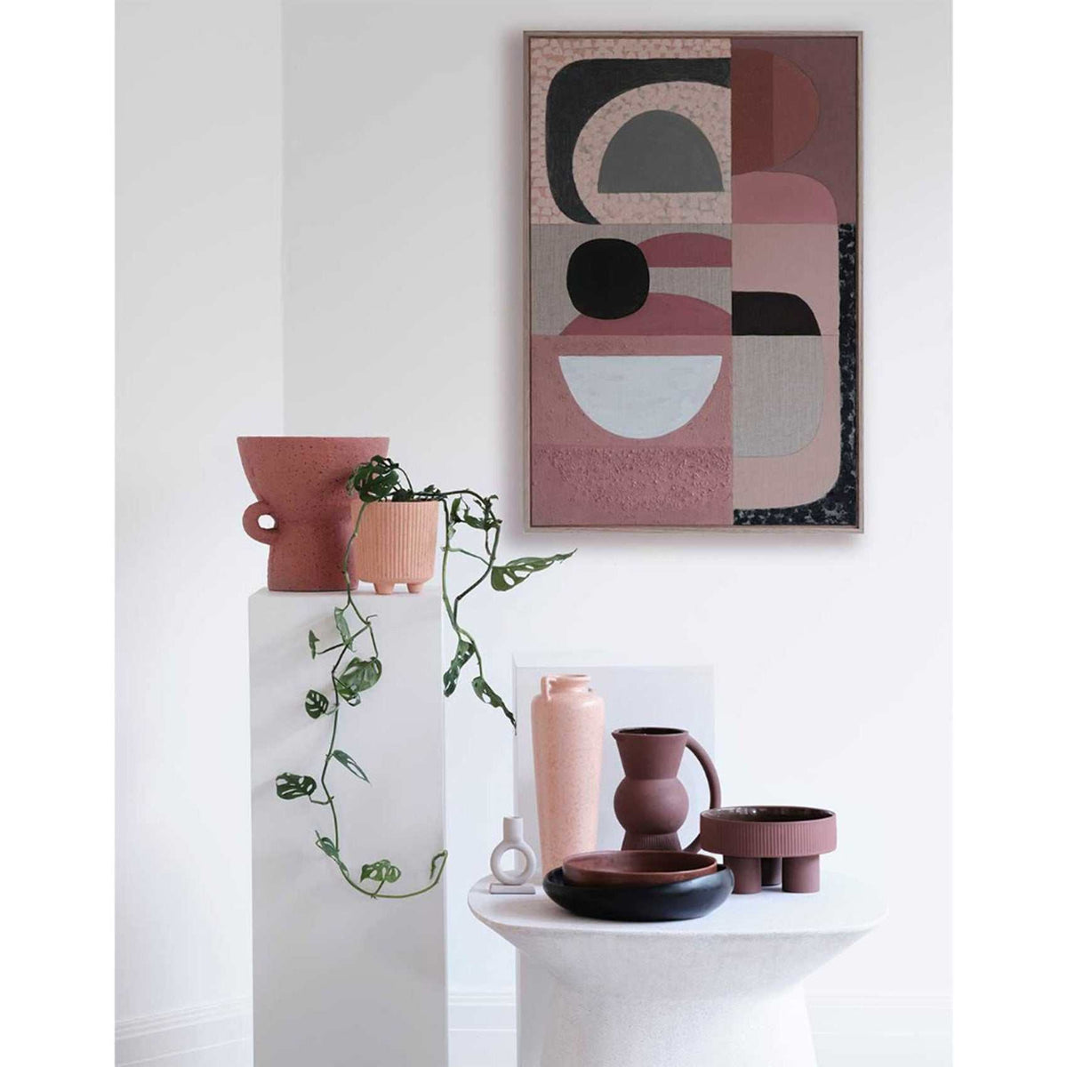 Pink Stucco - Giclee print artwork framed in raw oak on a white wall with vase and climber