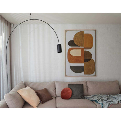A framed Giclee print featuring geometric shapes in earthy tones, hanging over a sofa with a black pendant light.