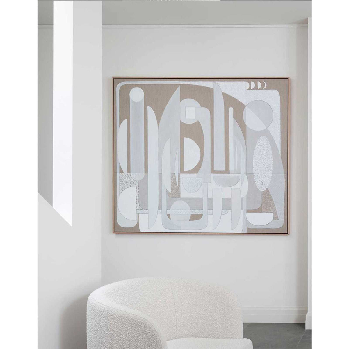 A Giclee print featuring geometric shapes in a stucco texture style, displayed above a white sofa.
